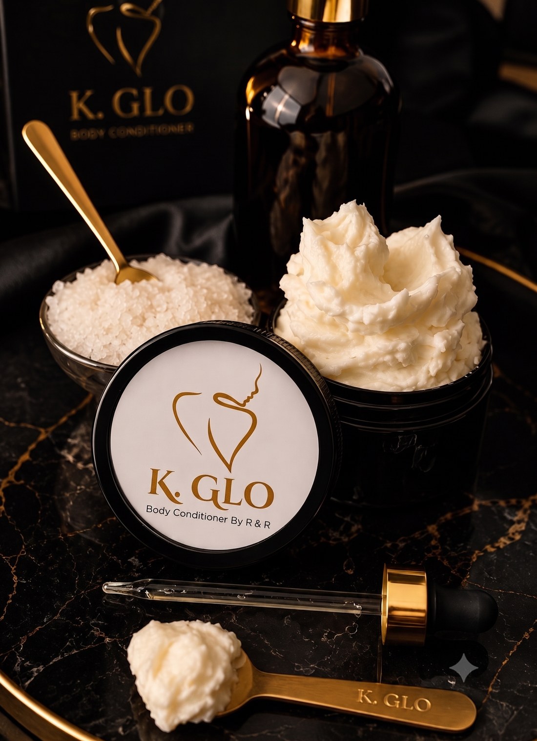 K.GLO whipped body conditioner, gold spoon, and dropper on black marble